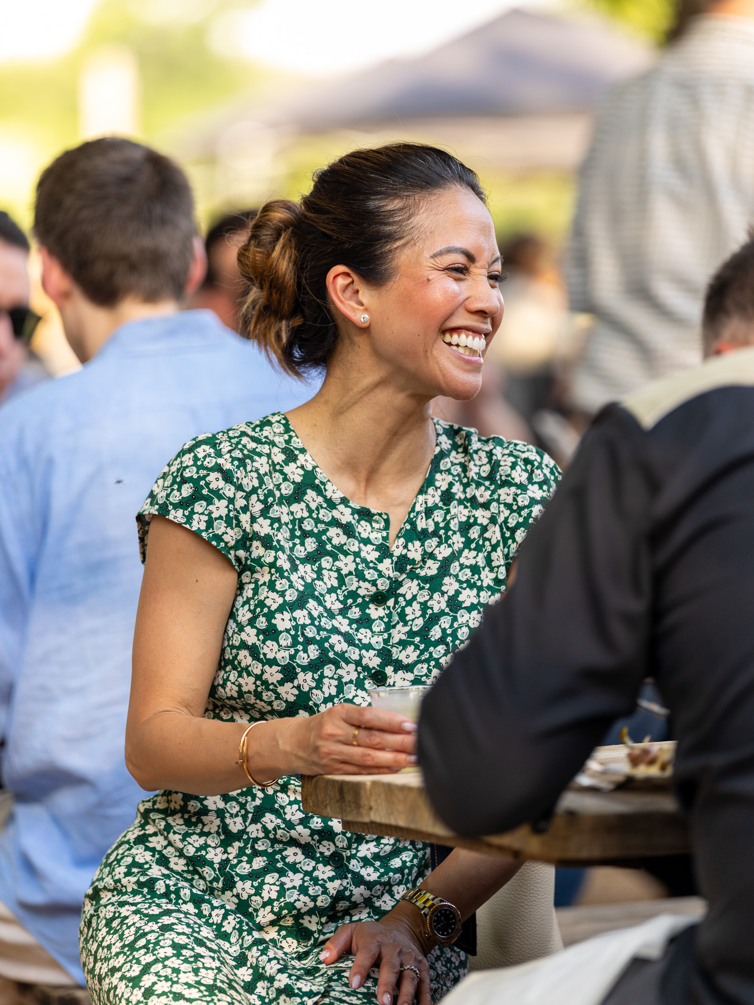 Guest laughing naturally during a lively outdoor corporate event