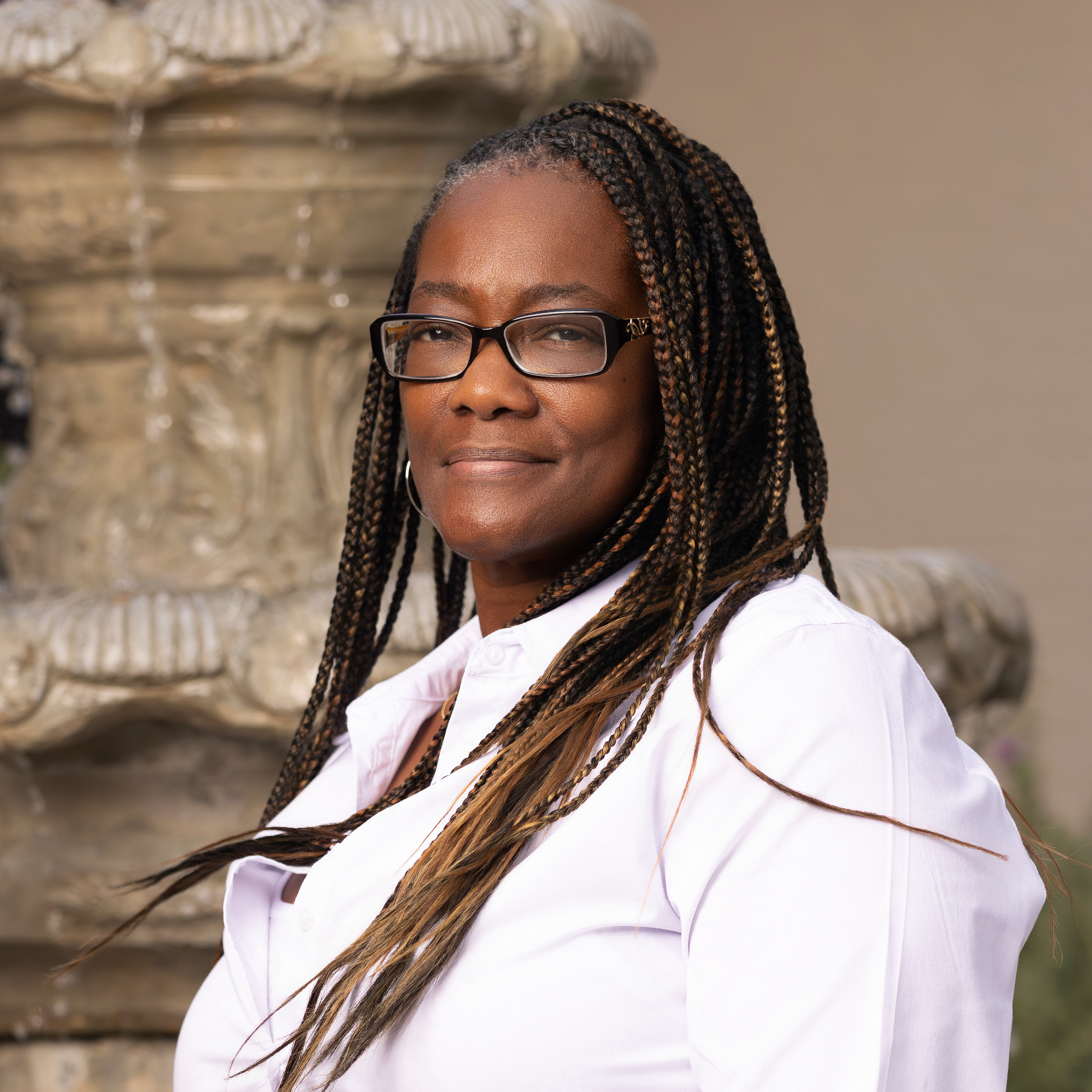 Black business professional with glasses photographed outdoors with a confident natural expression